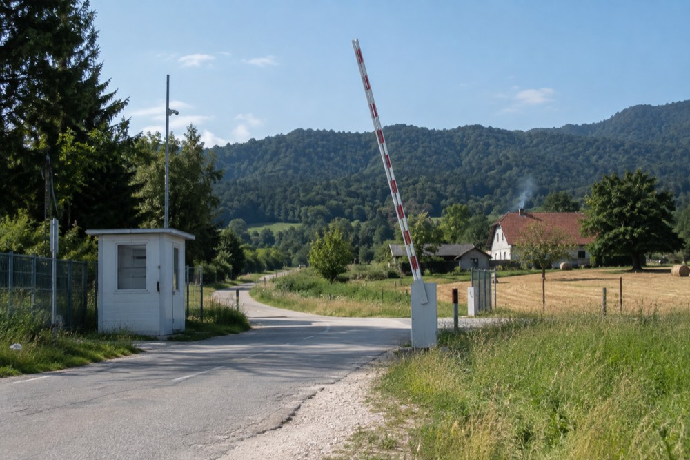 A country road sign at a border crossing between two European nations