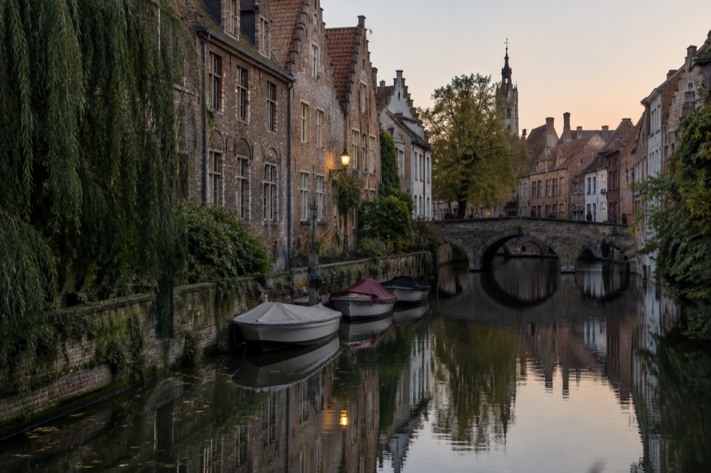 Canal in a European city lined with narrow gabled houses and small boats